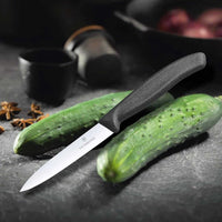 Victorinox Kuorimaveitsi 10 cm viipaloi kurkkua keittiöympäristössä, erinomainen valinta vihannesten käsittelyyn.