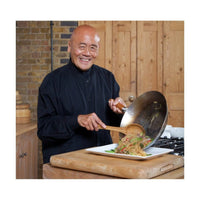 Ken Hom esittelee Classic Hiiliteräswokkia, 32cm, keittiössä, valmistamassa vihannesruokaa, laadukas ja kestävä keittiöväline.