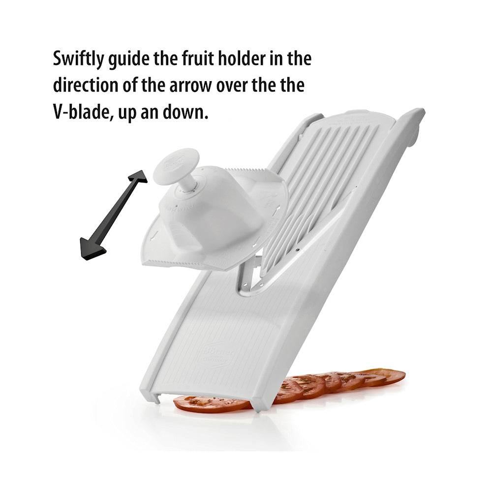 Börner Turvapidike mandoliiniin valkoinen kiinnitettynä V-leikkuriin, viipaloitu tomaatti alla. Turvapito suojaa sormia ruoanlaitossa.